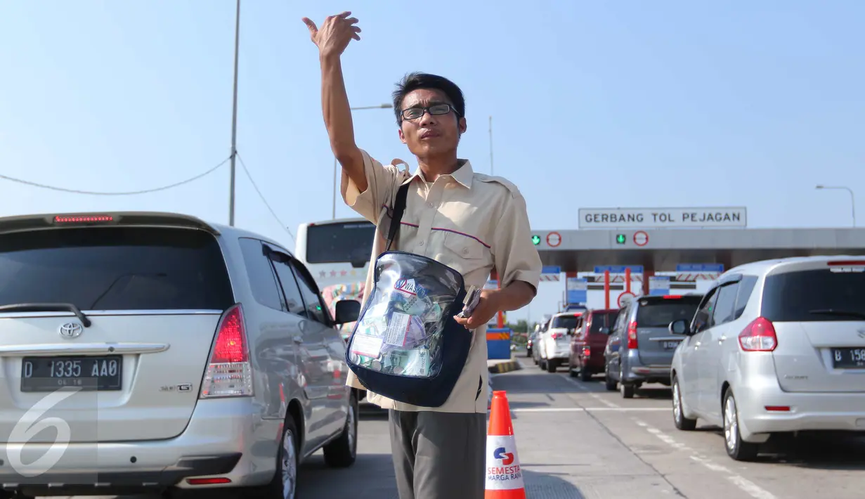 Petugas Lintas Marga Sedaya (LMS) saat mengatur arus kendaraan  di pintu keluar Pejagan, Jawa Tengah, Sabtu (2/7). Petugas melakukan sistem 'jemput bola' pembayaran tiket tol untuk mengurai kemacetan saat arus mudik. (Liputan6.com/Angga Yuniar)