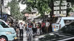 Warga saat menyaksikan petugas kepolisian menyemprotkan cairan disinfektan menggunakan kendaraan meriam air di Kawasan Petamburan, Jakarta, Minggu (22/11/2020). (merdeka.com/Iqbal S. Nugroho)