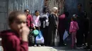 Kesenjangan antara kebutuhan dan pasokan kian melebar. Tampak dalam foto, para pengungsi Palestina menunggu untuk menerima makanan dari dapur amal di kamp pengungsi Nuseirat, Jalur Gaza Tengah pada 13 April 2026. (Eyad Baba/AFP)