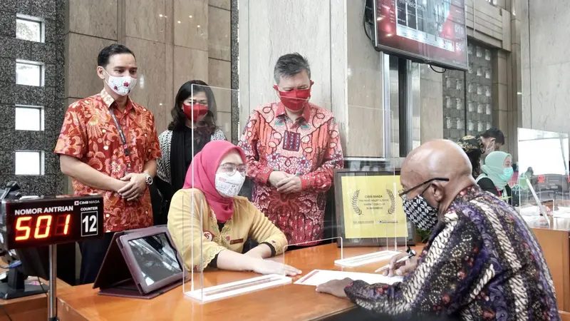 Head of Sales and Distribution CIMB Niaga Robby Mondong (kanan) menyapa dan menyaksikan pelayanan nasabah di Kantor Cabang Graha CIMB Niaga, Jakarta.