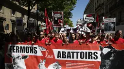 Sejumlah orang membawa spanduk saat menggelar unjuk rasa di Paris, Prancis, Sabtu (10/6). Mereka menuntut pemerintah untuk menutup rumah pemotongan hewan di Prancis. (AFP PHOTO / GEOFFROY VAN DER HASSELT)