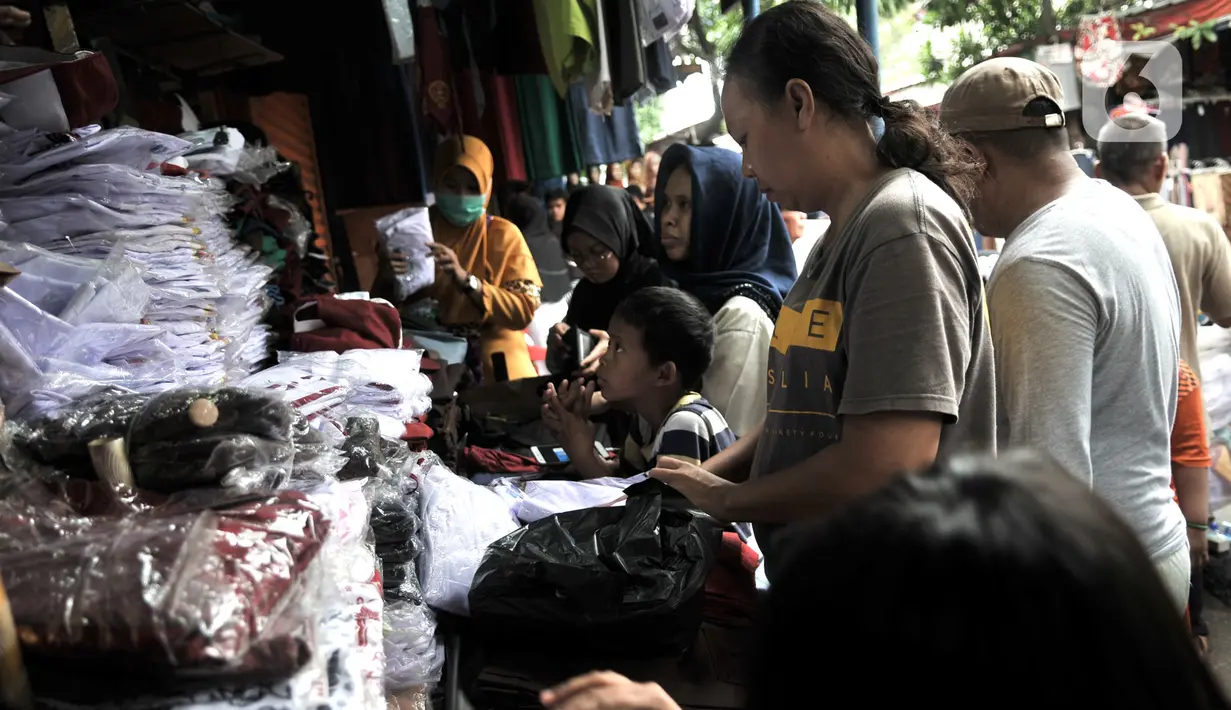 Warga berbelanja kebutuhan sekolah di Pasar Jatinegara, Jakarta, Minggu (5/1/2020). Jelang hari pertama belajar di semester baru, warga terdampak banjir di Kampung Melayu dan sekitarnya terpaksa membeli seragam baru untuk anaknya akibat banjir yang merendam rumah mereka. (merdeka.com/Iqbal Nugroho)
