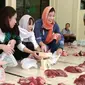 Tiga dari empat mahasiswi asal Jepang yang turut membagikan daging hewan kurban di Kampus Unitomo, Surabaya. (Liputan6.com/Dhimas Prasaja)