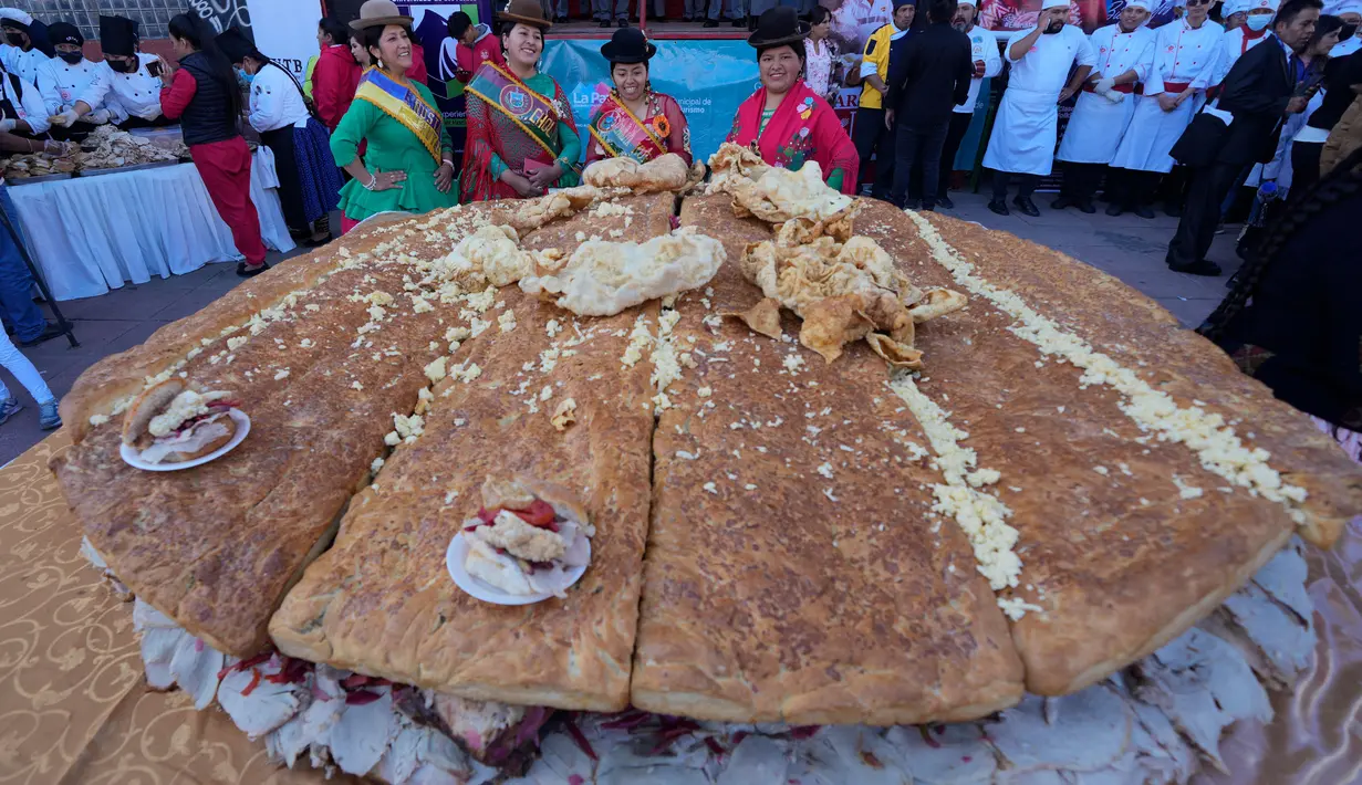 Cholitas berpose untuk foto selama presentasi "sandwich de chola" raksasa, di La Paz, Bolivia, Selasa, 2 Juli 2024. (AP Photo/Juan Karita)