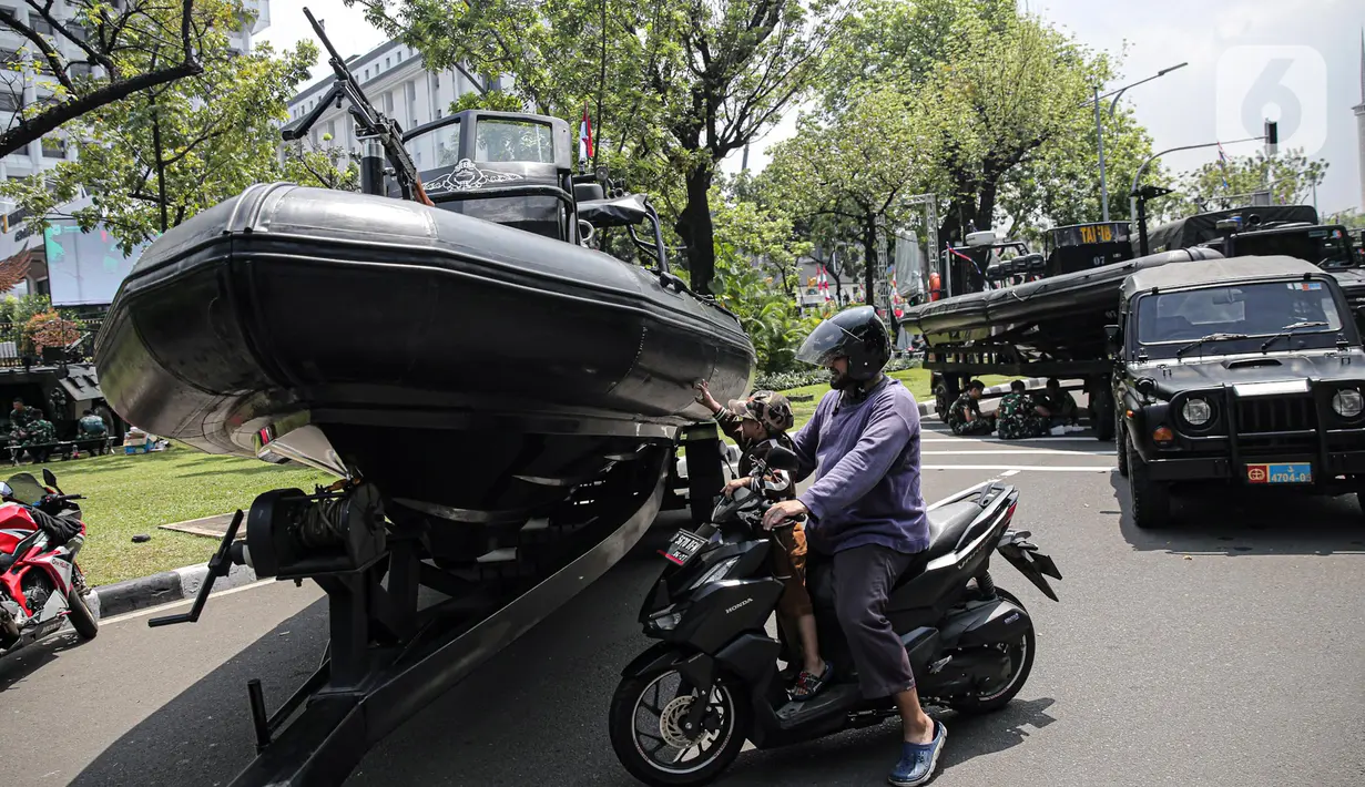 Seorang anak memegang kendaraan alat utama sistem senjata (alutsista) TNI yang berjajar di kawasan Istana Merdeka, Jakarta, Selasa (4/10/2022). Kegiatan ini dalam rangka HUT ke-77 TNI yang akan berlangsung di Istana Merdeka pada 5 Oktober besok. (Liputan6.com/Faizal Fanani)