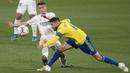 Pemain Real Madrid, Antonio Blanco, berebut bola dengan pemain Cadiz, Jose Mari, pada laga Liga Spanyol di Stadion Ramon de Carranza, Rabu (22/4/2021). Real Madrid menang dengan skor 3-0. (AFP/Jorge Guerrero)