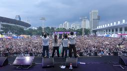 Group band Wali mengajak para penonton melakukan gestur berbentuk huruf W saat Kapanlagi Buka Bareng (KLBB) 2026 yang berlangsung di Stadion Madya, Senayan, Jakarta, Minggu (01/03/2026). (Bola.com/Bagaskara Lazuardi)