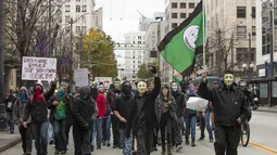 Demonstran mengenakan topeng Guy Fawkes saat menggelar aksi "Sejuta Topeng" di Washington, Amerika Serikat, Kamis(5/11/2015).  Para Demonstran memblokir lalu lintas disekitar Gedung Pengadilan federal dan kampus Amazon. (REUTERS/Jason Redmond)