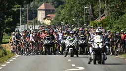 Rombongan pebalap dihentikan semenatara oleh regulator balapan karena terjadi demonstrasi perubahan iklim yang menutup rute balapan pada etape ke-10 Tour de France, antara Morzine dan Megeve, di Pegunungan Alpen Prancis, pada 12 Juli 2022. (AFP/Marco Bertorello)