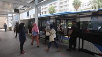 Penumpang turun dari bus Transjakarta di Halte Bundaran HI, Jakarta, Senin (12/10/2020). Sejumlah halte yang rusak pascademo Undang-Undang Cipta Kerja pada Kamis (8/10) sudah dapat digunakan kembali, salah satunya yakni halte Bundaran HI. (Liputan6.com/Herman Zakharia)