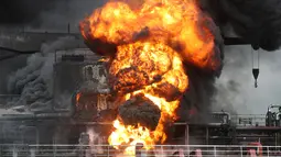 Api melahap kapal kargo di pelabuhan Ulsan, di pantai tenggara Korea Selatan (28/9/2019). Menurut pihak berwenang, sembilan pelaut terluka setelah kebakaran terjadi di kapal kargo dan menyebar ke kapal lain menyusul ledakan di kota pelabuhan tenggara Ulsan tersebut. (AFP/Yonhap)