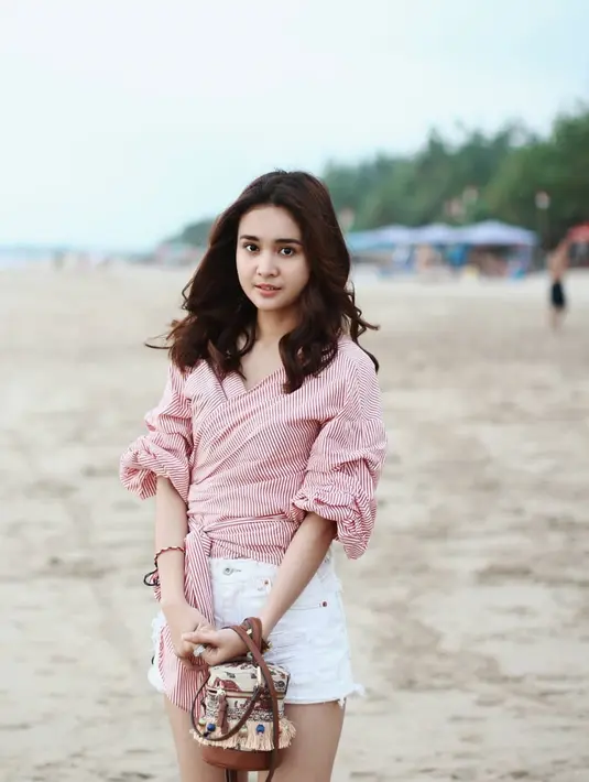 Michelle Ziudith juga pintar memadu padankan pakaian dengan tempat dimana ia berlibur. Saat di pantai, ia dengan cantiknya memakai pakaian dengan warna merah muda yang membuatnya terlihat lebih ceria. (Liputan6.com/IG/@michelleziu)