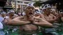 Penganut Shinto mandi dengan air dingin di Kuil Teppozu Inari, Tokyo, Jepang, 8 Januari 2023. Ritual Tahun Baru ini dilakukan untuk memurnikan jiwa dan raga. (Philip FONG/AFP)