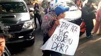 Seorang pelajar membawa poster untuk demo di Balai Kota Malang. Namun rencana ini gagal karena dirazia polisi lebih dulu (Liputan6.com/Zainul Arifin)