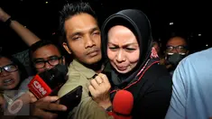 Istri Pelaksana Tugas (Plt) Gubernur Sumatera Utara Tengku Erry Nuradi, Evi Diana, menghindar dari wartawan usai diperiksa KPK, Jakarta, Kamis (5/11/15). Evi yang diperiksa sebagai saksi untuk Gatot Pujo Nugroho. (Liputan6.com/Helmi Afandi) 