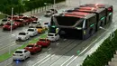Sebuah model bus besar mengangkangi sejumlah mobil di sebuah pameran di Beijing, Cina, (20/5). Bus ini seperti terowongan yang lebarnya memakan dua jalur jalan, jadi saat melintas kesannya mengangkangi jalan. (REUTERS/Hu Qingming)