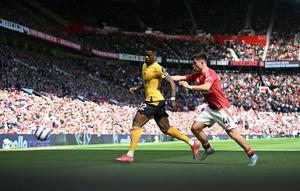 Pemain Manchester United, Harry Amass (kanan) membayangi pergerakan pemain Wolves, Nelson Semedoduring dalam laga lanjutan Liga Inggris 2024/2025 di Old Trafford, Inggris, Minggu (20/04/2025) waktu setempat. (AFP/Paul Ellis)