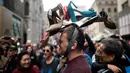 Seorang pria memakai topi yang terbuat dari sepatu wanita dalam Parade Paskah tahunan dan Festival Bonnet di sepanjang Fifth Avenue, New York, AS, Minggu (21/4). Parade Bonnet Easter merupakan parade pada perayaan Paskah di Kota New York yang sudah ada sejak tahun 1870. (Johannes EISELE / AFP)