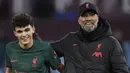 Bek Liverpool, Stefan Bajcetic bersama pelatih Jurgen Klopp merayakan kemenangan atas Aston Villa dalam laga Liga Inggris 2022/2023 di Villa Park, Birmingham (26/12/2022). Jika diturunkan dari awal laga saat melawan Real Madrid, bagi Stefan Bajcetic ini merupakan debutnya sebagai starter Liverpool di pentas Eropa. Sebelumnya ia telah tiga kali tampil bersama The Reds di Liga Champions musim 2022/2023 ini, namun semuanya berstatus pemain pengganti. (AFP/Oli Scarff)