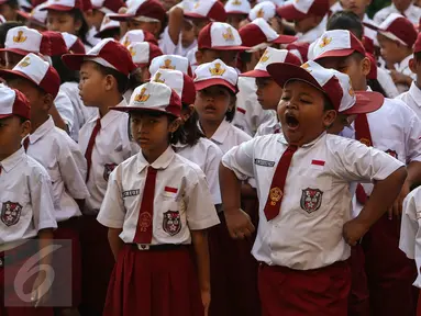 Seorang anak menguap ketika upacara pada hari pertama sekolah di SDN Pasar Baru 05, Jakarta, Senin (18/7). Usai libur Idul Fitri, para siswa kembali beraktivitas mengikuti pelajaran di sekolah untuk tahun ajaran 2015-2016. (Liputan6.com/Faizal Fanani)
