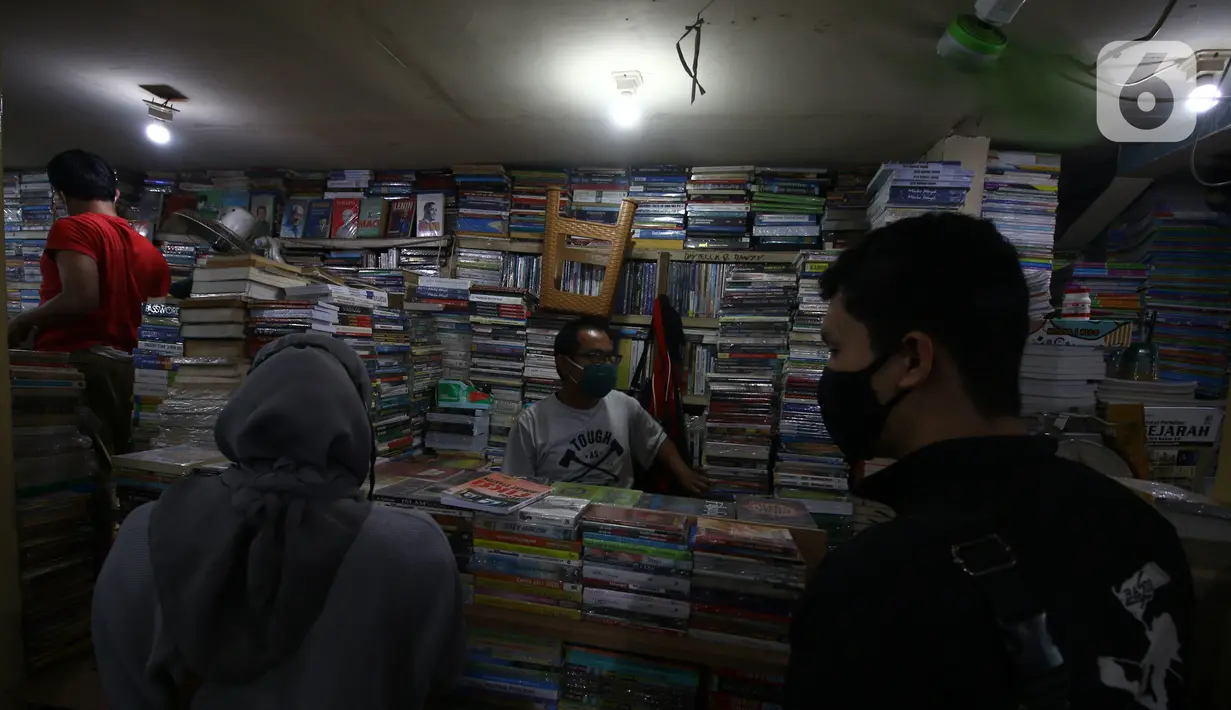 Pedagang buku melayani pembeli di Kwitang, Senen, Jakarta, Minggu (27/9/2020). Menurut keterangan para pedagang, penjualan buku di masa pandemi menurun hingga 50 persen dikarenakan masyarakat saat ini sudah beralih melakukan transaksi pembelian secara daring. (Liputan6.com/Angga Yuniar)