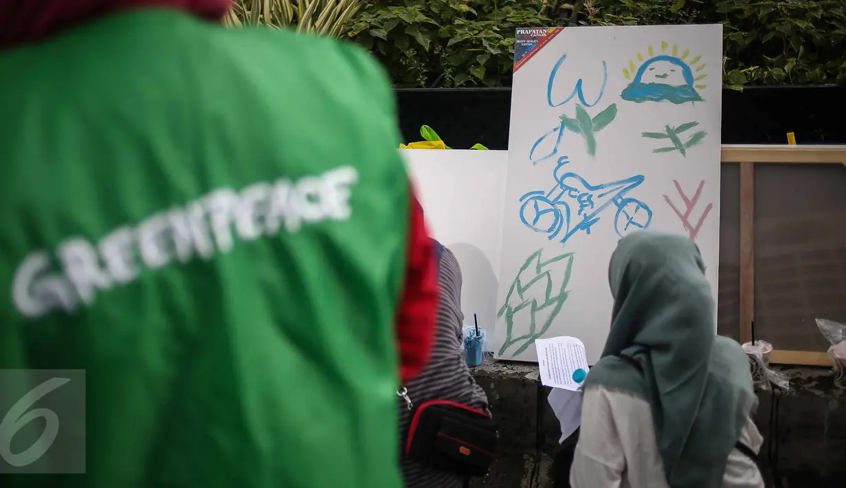 Seorang pengunjung mengikuti aksi melukis di kanvas disela kegiatan Car free Day (CFD) di kawasan Bundaran HI, Jakarta, Minggu (12/2). Aksi yang digelar oleh Greenpeace itu untuk mengenalkan masyarakat tentang sadar polusi. (Liputan6.com/Faizal Fanani)