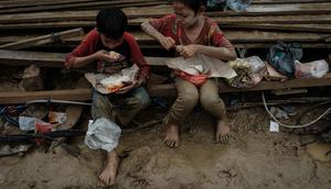 Anak-anak memakan makanan yang dibagikan di Babo, Aceh Tamiang, pada Senin 15 Desember 2025. Ancaman gangguan kesehatan menghantui anak-anak korban bencana banjir bandang dan tanah longsor yang terjadi di berbagai wilayah di Aceh, Sumatera Utara, dan Sumatera Barat. (Yasuyoshi CHIBA/AFP)