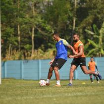 Yann Motta (rompi biru) dibayangi Dalberto Luan dalam sesi latihan Arema FC di lapangan ARG, Kabupaten Malang, Rabu (02/07/2025). (Iwan Setiawan/Bola.com)