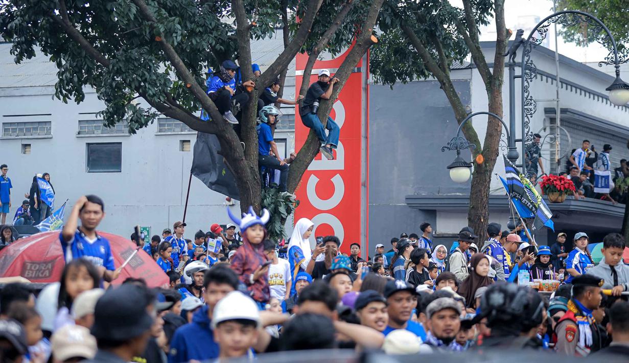 Warga menyambut tim dan ofisial Persib Bandung saat pawai perayaan gelar juara BRI Super League 2025/2026 di Bandung, Jawa Barat, Minggu (24/5/2026). (Bola.com/Bagaskara Lazuardi)