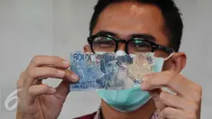 Petugas menunjukkan uang kertas rusak yang ditukarkan warga di Bank Indonesia, Jakarta, Selasa (26/1). BI menerapkan kebijakan untuk mengganti atau menukar uang tidak layak edar dengan uang yang layak edar (Liputan6.com/Angga Yuniar)
