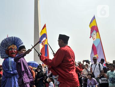 Warga menyaksikan penampilan kesenian palang pintu pada gelaran Lebaran Betawi di kawasan Monumen Nasional (Monas), Jakarta, Minggu (21/5/2023). (merdeka.com/Iqbal S. Nugroho)