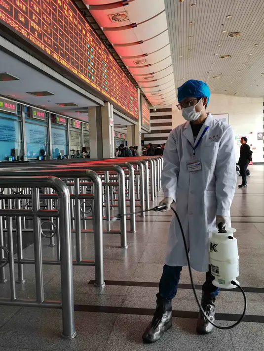 Petugas menyemprotkan cairan disinfektan di Stasiun Kereta Api Yingtan di Nanchang di Provinsi Jiangxi Tengah, China (22/1/2020). Pemerintah China pada Kamis (23/1/2020) telah menutup Kota Wuhan berpenduduk lebih dari 11 juta orang dan pusat penyebaran virus corona. (AFP Photo/STR)