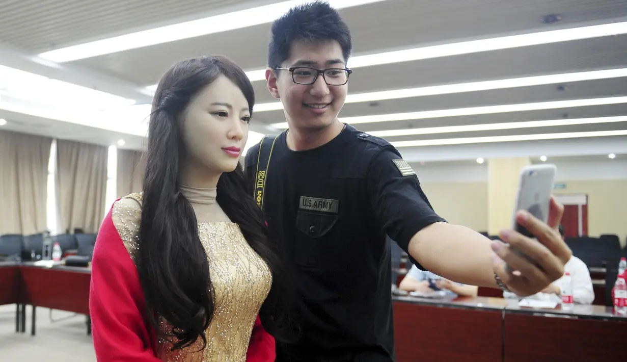 Pengunjung pria saat berselfie dengan Jiajia saat acara peluncurannya di Hefei, Provinsi Anhui, Cina, Jumat (15/4). Jiaja dapat berbicara dan menjawab wawancara dari seorang wartawan yang hadir. (REUTERS/Stringer)