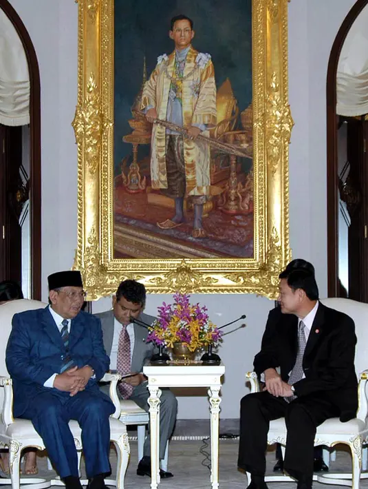 KH Hasyim Muzadi saat masih menjadi Ketua PBNU berbincang dengan PM Thailand Thaksin Shinawatra di Gedung Pemerintahan Bangkok, 28 Maret 2004. KH Hasyim Muzadi wafat di usia 73 tahun, Kamis pagi tadi sekitar pukul 06.15 WIB. (AFP Photo/Government House)