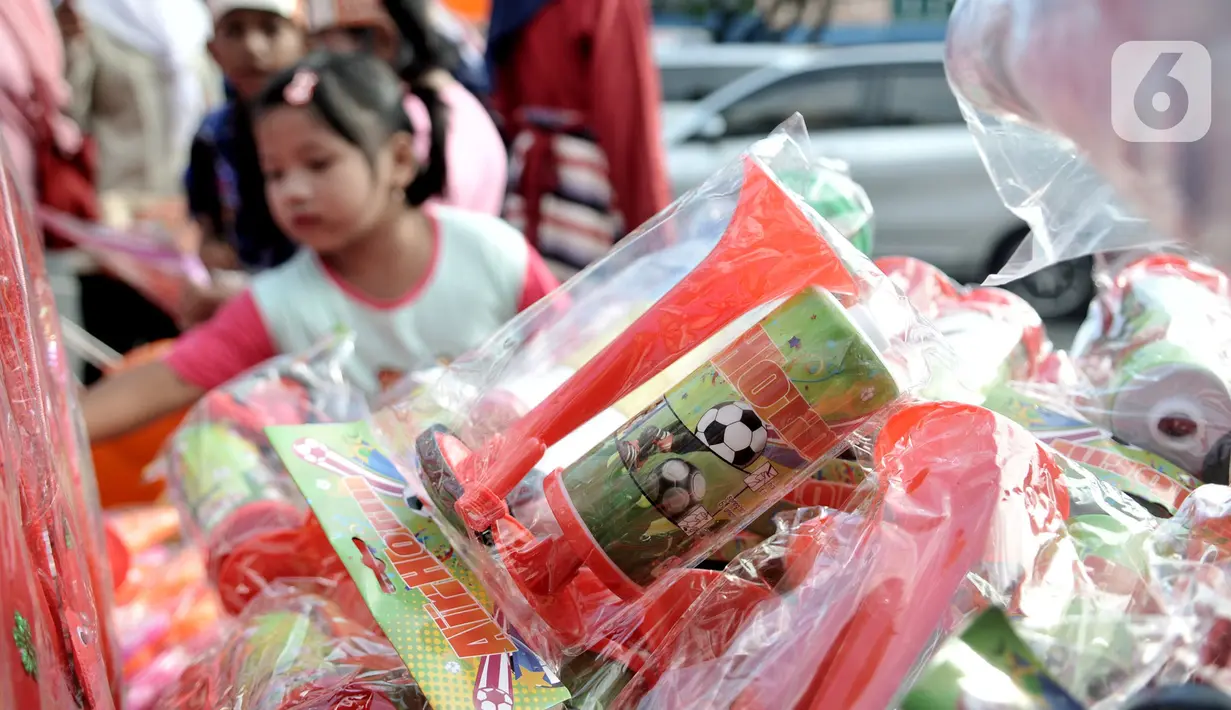 Seorang anak memilih terompet berbahan plastik yang dijual di Pasar Gembrong, Jakarta, Minggu (29/12/2019). Penjualan terompet plastik jelang perayaan malam tahun baru kali ini lebih marak akibat pasokan bahan baku sulit didapat. (merdeka.com/Iqbal Nugroho)