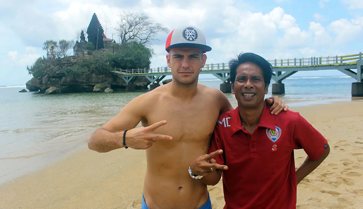Asisten pelatih Arema Cronus, Pasek Wijaya, foto bersama pemain asal Spanyol, Kiko Insa, usai latihan fisik di Pantai Balekambang, Malang. (Bola.com/Kevin Setiawan)