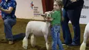 Seorang anak memeluk domba saat sebuah kontes dalam Pameran dan Rodeo Texas Utara (North Texas Fair and Rodeo) 2020 di Denton, Texas, 22 Oktober 2020. Pameran dan Rodeo Texas Utara digelar pada 16-24 Oktober dengan menampilkan pertunjukan ternak, kontes, rodeo, serta karnaval. (Xinhua/Dan Tian)