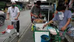 Seorang pria yang mengenakan masker membeli makanan dari warung kaki lima di kota Quezon, Filipina, Selasa (22/9/2020). Presiden Filipina Rodrigo Duterte mengatakan telah memperpanjang status masa darurat virus corona (Covid-19) di negaranya hingga satu tahun ke depan. (AP Photo/Aaron Favila)