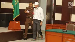 Terdakwa kasus penembakan dr Letty Sultri, dr Helmi memasuki ruang sidang PN Jakarta Timur, Kamis (29/3). Helmi didakwa menembak istrinya sebanyak enam kali di bagian badan. (Liputan6.com/Herman Zakharia)