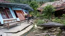 Berdasar data BNPB, hingga Minggu 8 Februari 2026, tercatat ada sekitar 2.453 orang warga Desa Padasari telah meninggalkan rumah mereka ke pengungsian. Tampak dalam foto, seorang pria menyelamatkan barang-barangnya setelah pergerakan tanah melanda permukiman mereka di desa Padasari, Tegal, Jawa Tengah, Senin 9 Februari 2026. (DEVI RAHMAN/AFP)