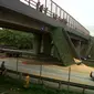 Bak tersebut berdiri secara vertikal dengan bertumpu pada jembatan. Posisinya melintang di tengah jalan Tol Jakarta-Merak. (Yandhi Deslatama/Liputan6.com)