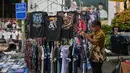 Sensus Ekonomi 2026 bertujuan memotret kondisi riil usaha mikro pasca-pandemi untuk dasar kebijakan permodalan, perizinan, dan subsidi yang lebih tepat sasaran. Tampak dalam foto, seorang pedagang menata kaos sambil menunggu pelanggan di kios pakaiannya di salah satu ruas jalan, Surabaya, Jawa Timur, pada Minggu 19 April 2026. (JUNI KRISWANTO/AFP)
