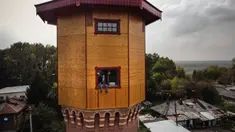 Pengusaha Rusia Alexander Lunev duduk di jendela bekas menara air, yang diubah menjadi apartemen, di kota Tomsk, Siberia pada 7 September 2020. Alexander Lunev, mantan presenter radio dari Kota Tomsk telah membeli menara air berusia 125 tahun dari kotamadya pada tahun 2012. (Alexander NEMENOV / AFP)
