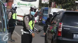 Petugas mengatur lalu lintas di sepanjang Simpang Cagak Nagreg, Jawa Barat, Minggu (3/7).H-3 menjelang lebaran volume kendaraan yang melintas meningkat ditambah dengan aktivitas pasar yang ada di kawasan tersebut. (Liputan6.com/Immanuel Antonius)