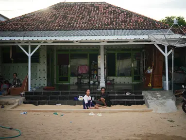 Warga menghabiskan sore mereka di bak pasir yang tersedia di hampir setiap rumah di Desa Legung Timur, Sumenep, Madura, Selasa 9 September 2025. (AP Photo/Dita Alangkara)