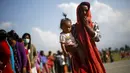 Seorang korban gempa menggendong anaknya mengantre untuk  mendapatkan makanan dan minuman di lokasi pengungsian, di Kathmandu, Nepal, Senin (4/5/2015). Gempa berkekuatan 7,8 yang meluluhlantakkan Nepal pada 25 April 2015 lalu. (REUTERS/Adnan Abidi)