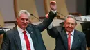 Presiden baru Kuba Miguel Díaz-Canel (kiri) dan Presiden Kuba Raul Castro mengangkat tangan mereka di Majelis Nasional, Havana, Kamis (19/4). Raul Castro mengumumkan Wakil Presiden Miguel Diaz-Canel sebagai penggantinya. (Alexandre Meneghini/Pool via AP)