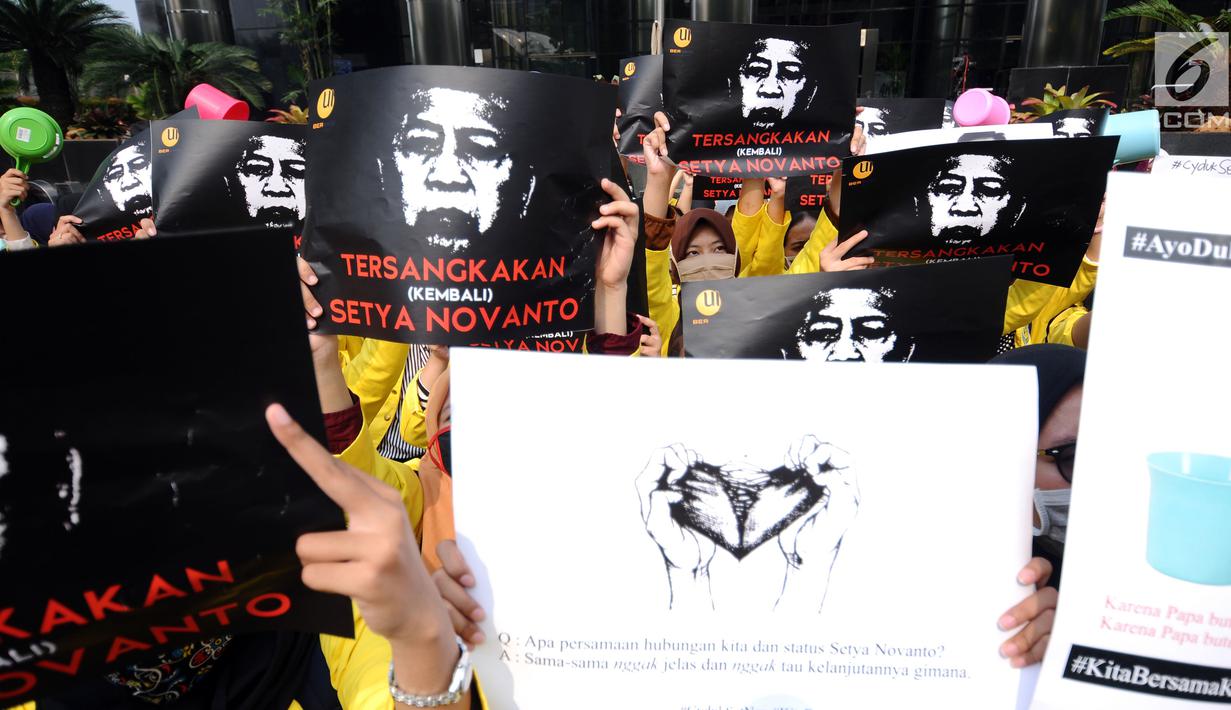 Sejumlah mahasiswa yang tergabung dalam UI Beraksi membentangkan foto Setya Novanto saat aksi di depan Gedung KPK, Jakarta, Jumat (13/10). Mereka meminta KPK menetapkan kembali status tersangka kepada Setya Novanto. (Liputan6.com/Helmi Fithriansyah)