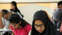 Peserta melihat soal SBMPTN 2018 di Kampus Universitas Islam Negeri (UIN) Syarif Hidayatullah, Tangerang Selatan, Selasa (8/5). Sementara 14 lainnya merupakan peserta SBMPTN berkebutuhan khusus. (Merdeka.com/Arie Basuki)
