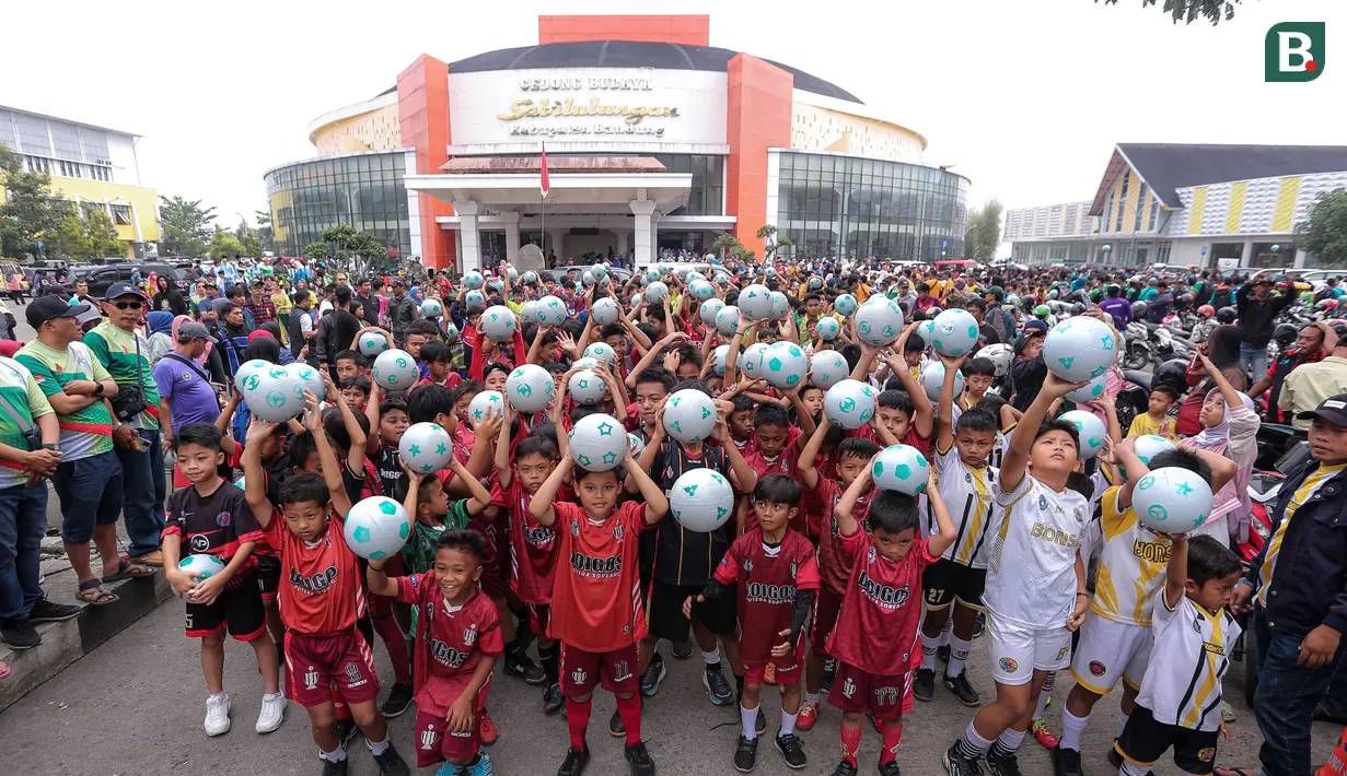 Para pesepak bola cilik dari beberapa SSB di Kabupaten Bandung saat mengikuti kegiatan menggiring bola raksasa dalam rangkaian acara Trophy Experience menyambut Piala Dunia U-17 2023 di Plaza Upakarti, Soreang, Kabupaten Bandung, Minggu (22/10/2023) sore WIB. (Bola.com/Bagaskara Lazuardi)